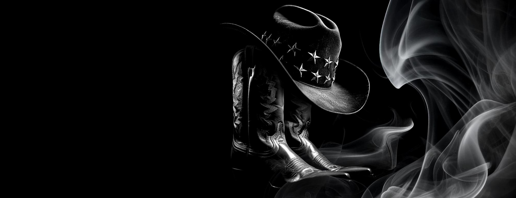 Image of black cowboy boots and hat with smoky atmosphere