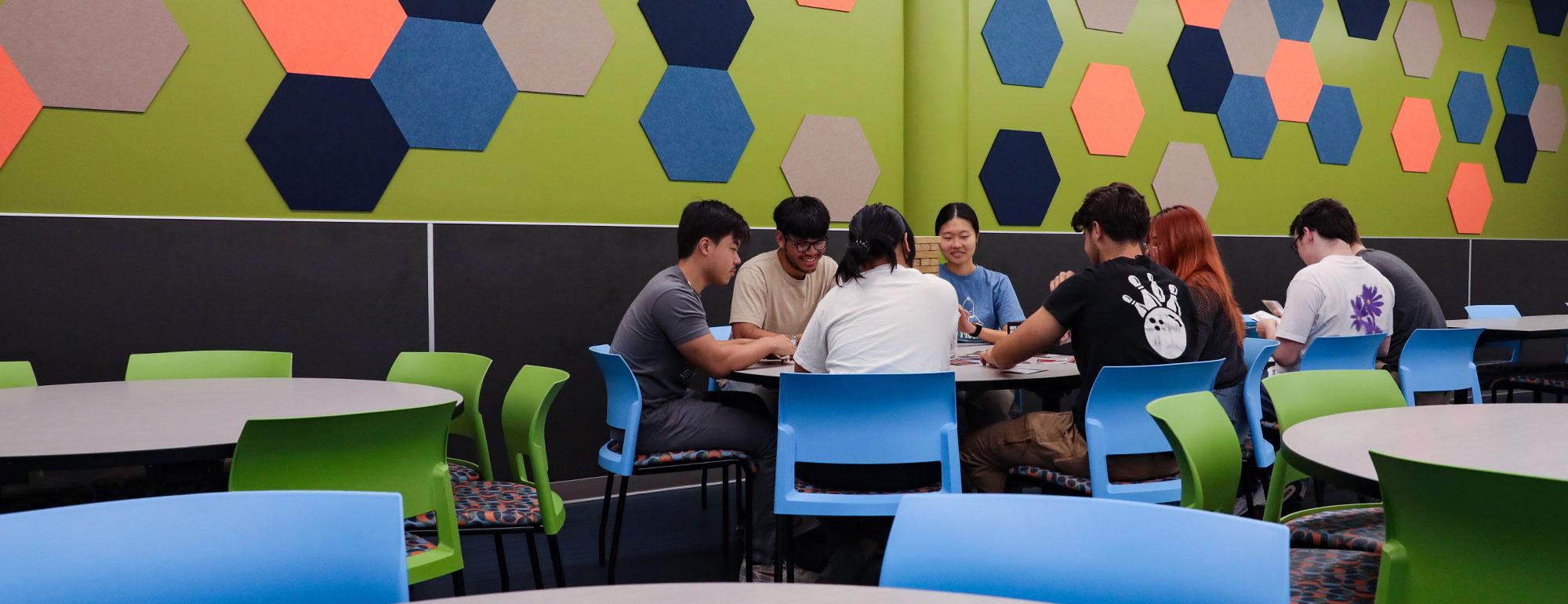 A group of students plays board games in the Rec Room in the Games Area