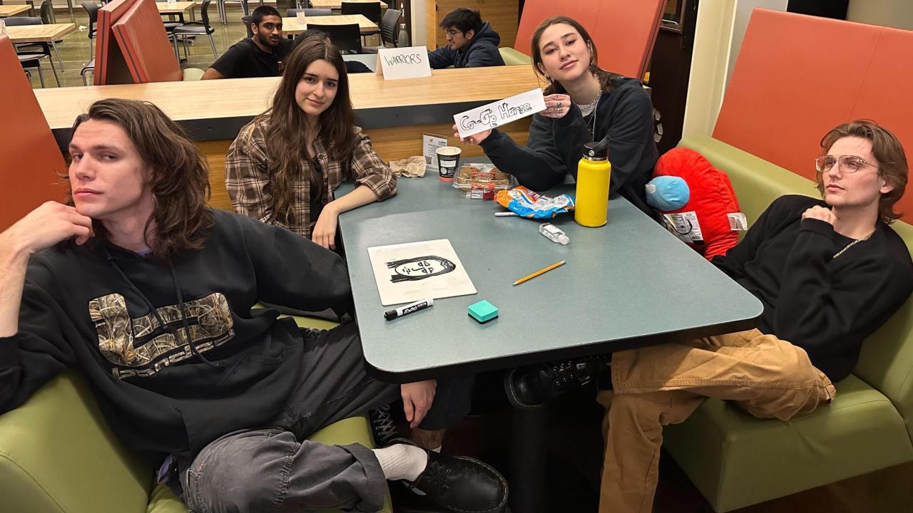People gathered around a table in the Coffee House for MU Trivia Night