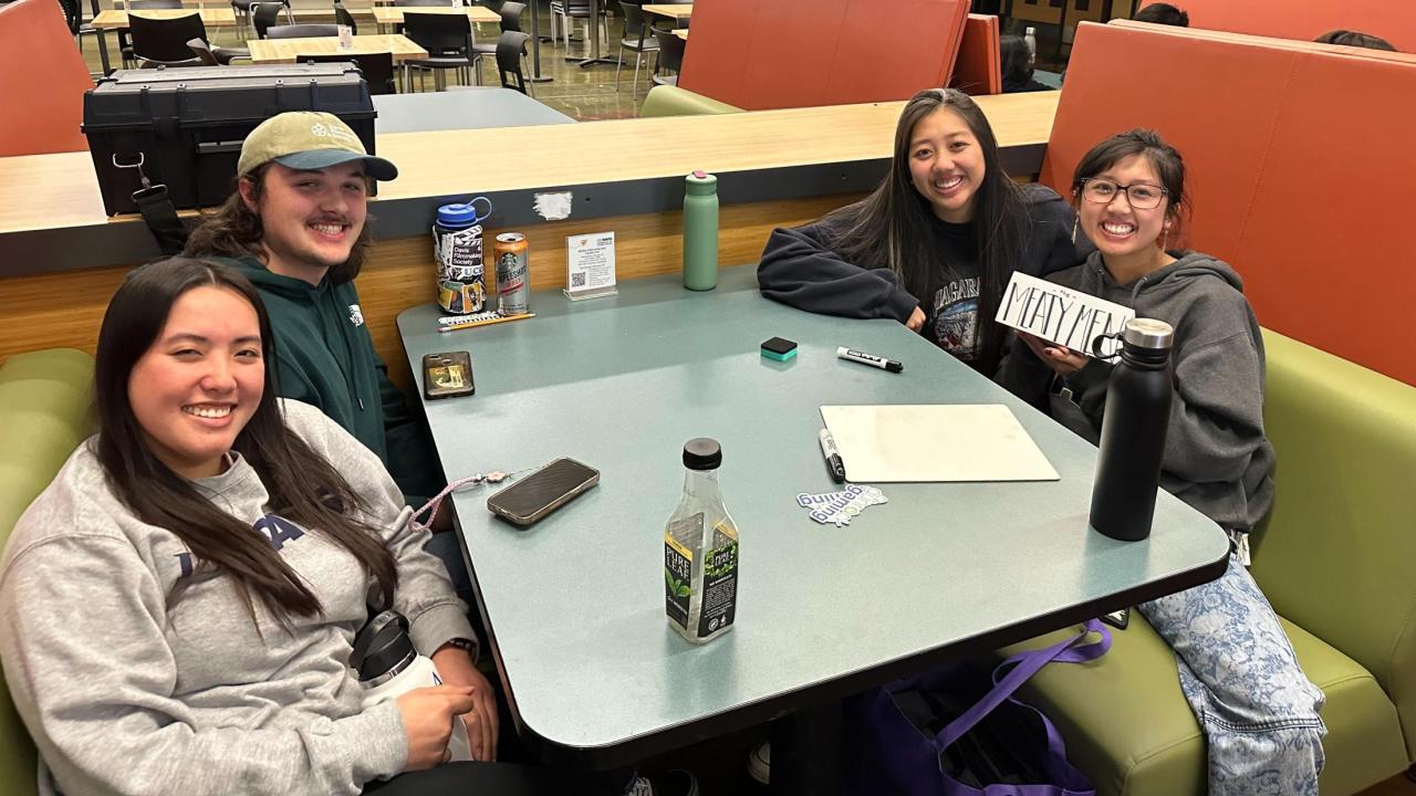 People gathered around a table in the Coffee House for MU Trivia Night