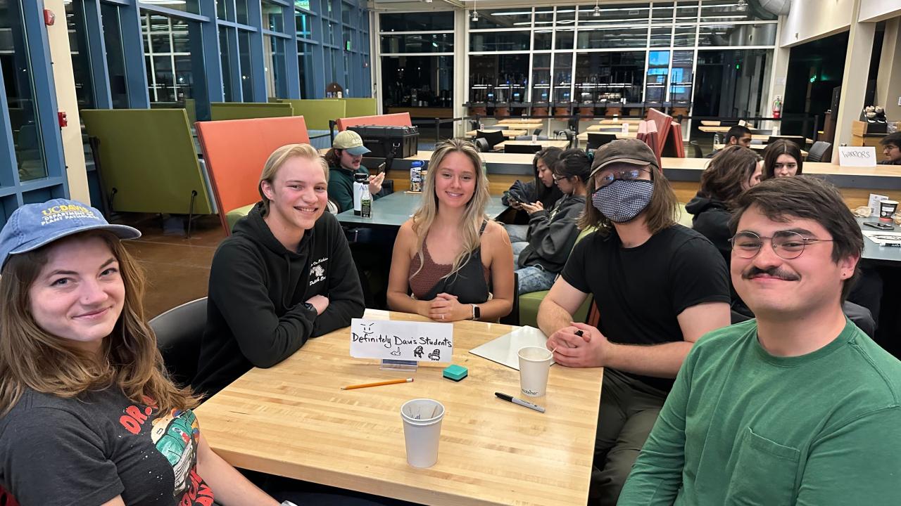 People gathered around a table in the Coffee House for MU Trivia Night