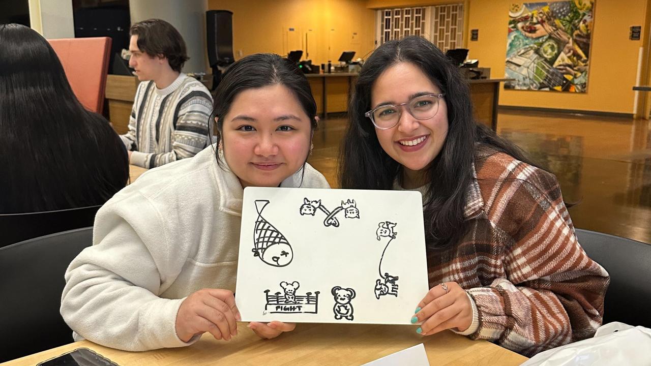 People gathered around a table in the Coffee House for MU Trivia Night