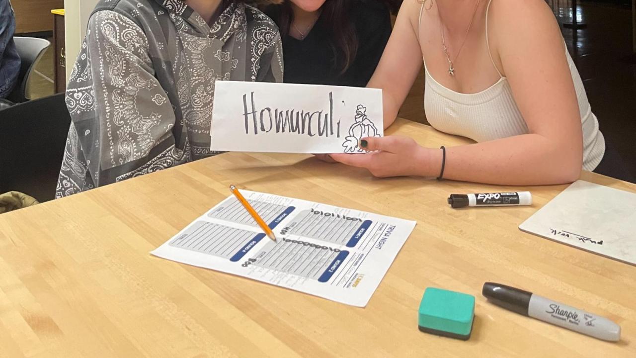 People gathered around a table in the Coffee House for MU Trivia Night