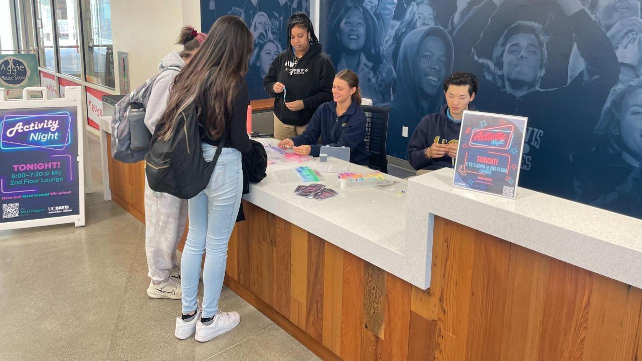 Patrons at the MU Information Desk participating in keychain making