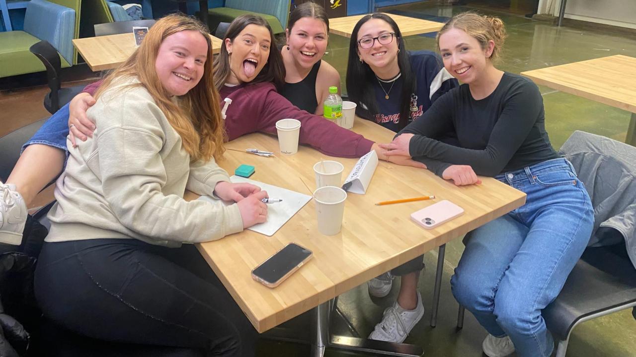 People gathered around a table in the Coffee House for MU Trivia Night