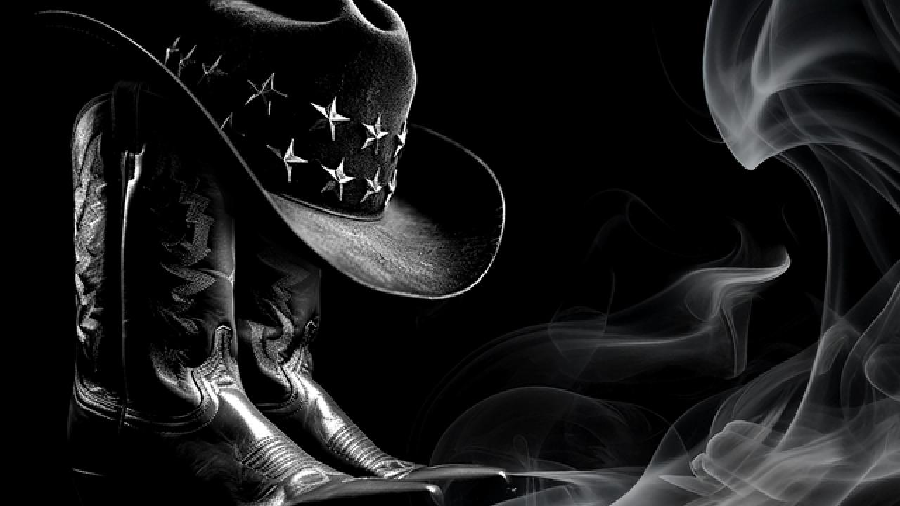 black and white photo of cowboy boot and hat