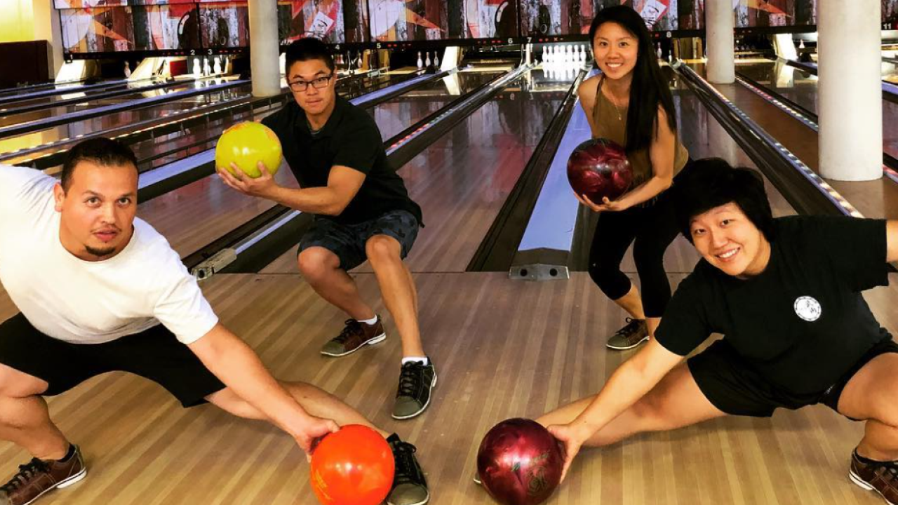 Four UC Davis students posing in anime poses while bowling at the Games Area