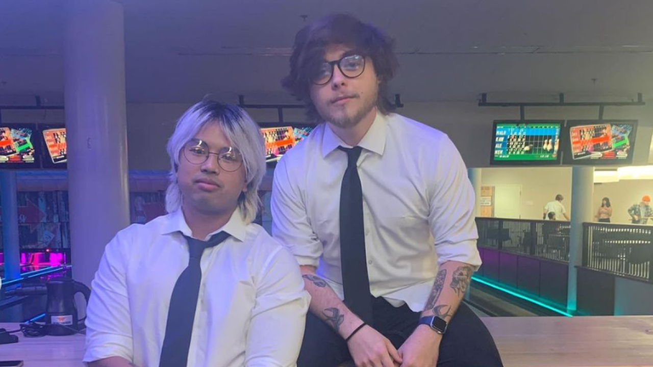 Two UC Davis student workers posing in suits at the Games Area during Emo Night Spring Quarter 2022