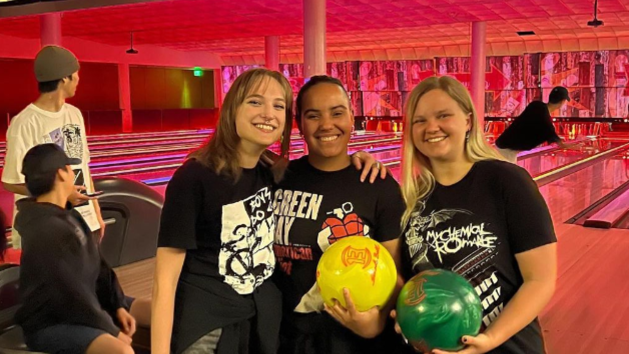 Three UC Davis students posing while bowling at the Games Area during Emo Night Spring Quarter 2022