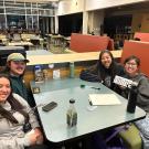 People gathered around a table in the Coffee House for MU Trivia Night