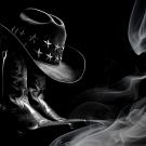 black and white photo of cowboy boot and hat